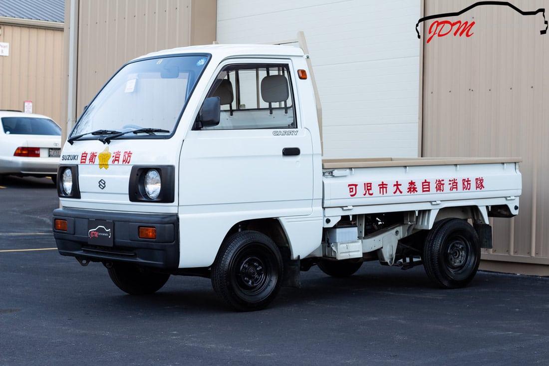 The different bed types of a Kei truck includes the flatbed, a standard for Kei Truck models.
Image of a white flatbed Kei.